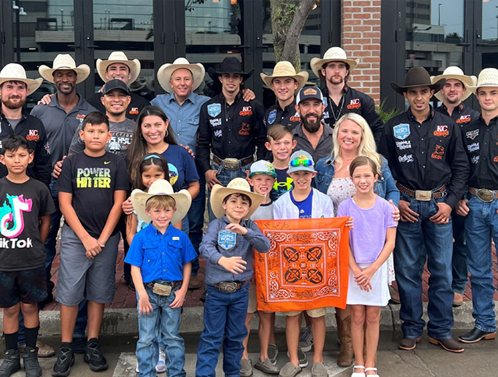 Kansas City Outlaws team members posing with kids